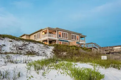 a house sitting on top of a sandy beach at Pelican Paradise in Seacrest