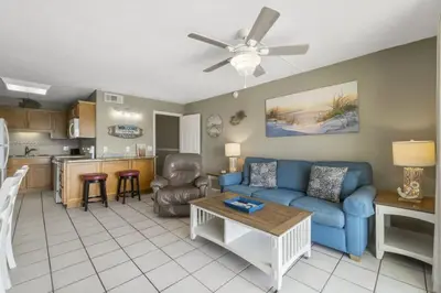 a living room with a blue couch and a table at The Summit 1128 in Panama City Beach