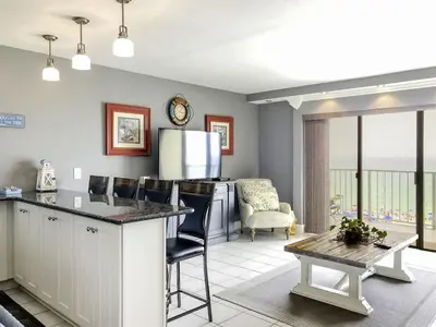 a kitchen with a counter and a living room at The Summit 611 in Panama City Beach