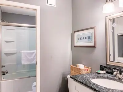 a bathroom with a sink and a toilet and a mirror at The Summit 611 in Panama City Beach