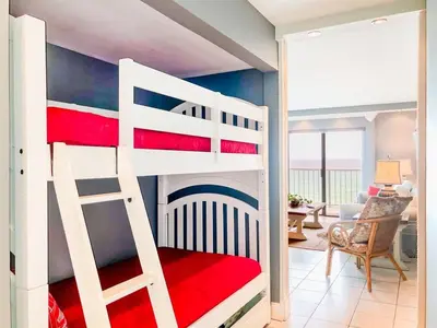 a bedroom with a bunk bed and a living room at The Summit 611 in Panama City Beach