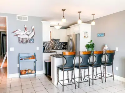 a kitchen with bar stools and a refrigerator at The Summit 611 in Panama City Beach