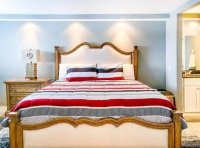 a bedroom with a large bed with red and white sheets at The Summit 611 in Panama City Beach