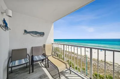 a balcony with two chairs and a view of the beach at The Summit 702 in Panama City Beach