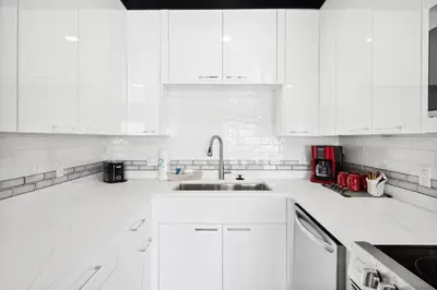 a white kitchen with white cabinets and a sink at The Summit 702 in Panama City Beach