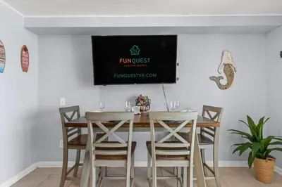 a dining room with a table with chairs and a tv at The Summit 1409 in Panama City Beach