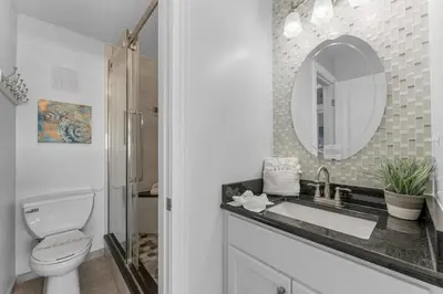 a bathroom with a sink and a toilet and a mirror at The Summit 1130 in Panama City Beach