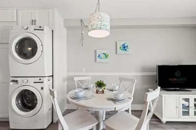 a dining room with a table and a washing machine at The Summit 515 in Panama City Beach