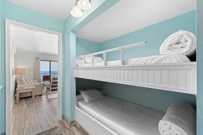 a room with two bunk beds with a couch in it at The Summit 1030 in Panama City Beach