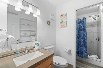 a bathroom with a sink and a toilet and a mirror at The Summit 1030 in Panama City Beach