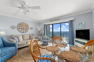 a living room with a table and chairs and a couch at The Summit 502 in Panama City Beach
