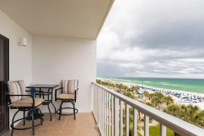 a balcony with a table and chairs and the beach at The Summit 504 in Panama City Beach