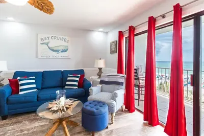 a living room with a blue couch and red curtains at The Summit 504 in Panama City Beach