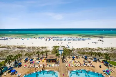 an overhead view of a beach with swimming pools and people at The Summit 1017 in Panama City Beach