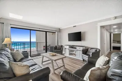 a living room with a couch and a table at Moondrifter 502 in Panama City Beach