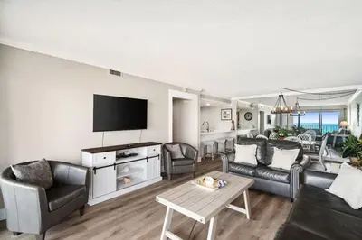a living room with a couch and a tv at Moondrifter 502 in Panama City Beach