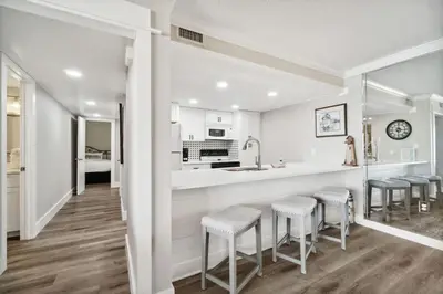 a kitchen with a counter and stools in a room at Moondrifter 502 in Panama City Beach