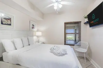 a white bedroom with a large bed and a window at Majestic T2 - 1606 in Panama City Beach