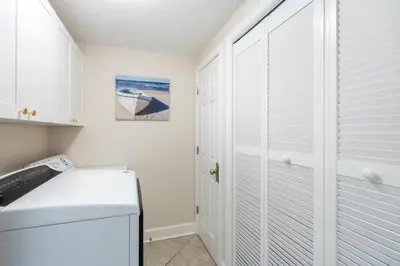 a kitchen with white cabinets and a white refrigerator at Majestic T2 - 1606 in Panama City Beach