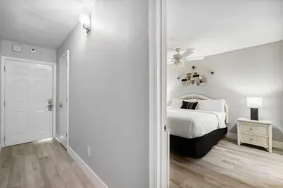 a white bedroom with a bed and a ceiling fan at The Summit 531 in Panama City Beach