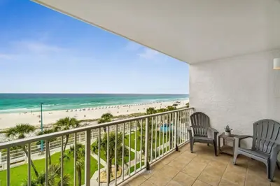 a balcony with two chairs and a view of the beach at The Summit 531 in Panama City Beach