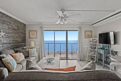 a living room with a couch and a large window with the ocean at The Summit 816 in Panama City Beach