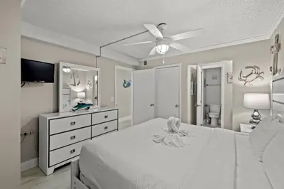 a bedroom with a white bed and a ceiling fan at The Summit 816 in Panama City Beach