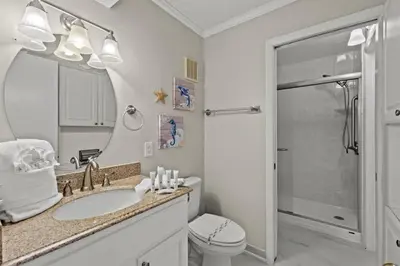 a bathroom with a sink and a toilet and a mirror at The Summit 816 in Panama City Beach