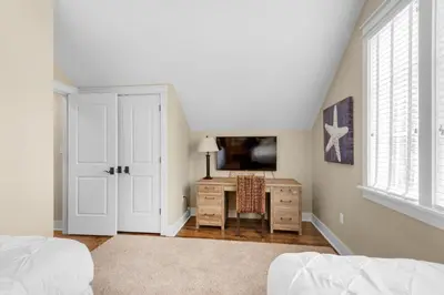 a bedroom with a bed and a desk with a tv at Sunny Side Up in Santa Rosa Beach