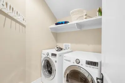 a white laundry room with a washer and dryer at Sunny Side Up in Santa Rosa Beach