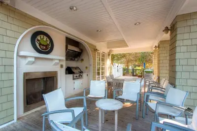 a patio with chairs and tables and a fireplace at Sunny Side Up in Santa Rosa Beach
