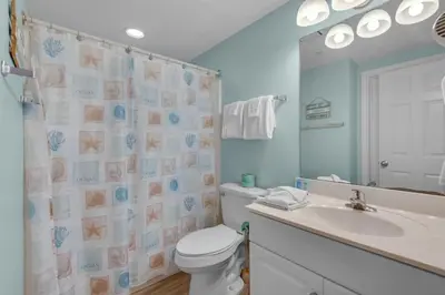 a bathroom with a toilet and a sink and a mirror at Majestic Beach Towers 2-1708 in Panama City Beach