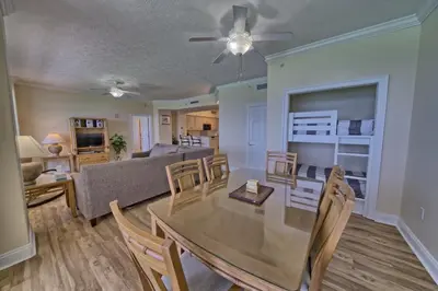 a dining room and living room with a table and chairs at Luxurious Tropical Condo with Breathtaking Gulf View - Unit 2006 in Panama City Beach