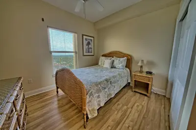 a bedroom with a bed and a nightstand and a window at Luxurious Tropical Condo with Breathtaking Gulf View - Unit 2006 in Panama City Beach