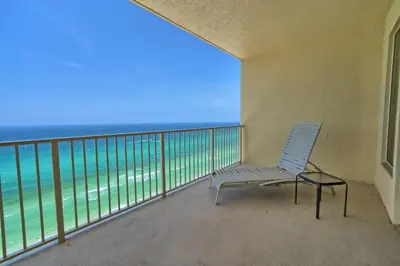 a chair on a balcony with a view of the ocean at Luxurious Tropical Condo with Breathtaking Gulf View - Unit 2006 in Panama City Beach