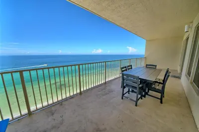 a balcony with a table and chairs and the ocean at Wondrous Condo with Beach Access and Poolside Beach - Unit 2103 in Panama City Beach