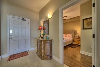 a bedroom with a bed and a door with a table at Roomy Oceanfront Condo with Breathtaking View and Beachside Pool - Unit 1906 in Panama City Beach
