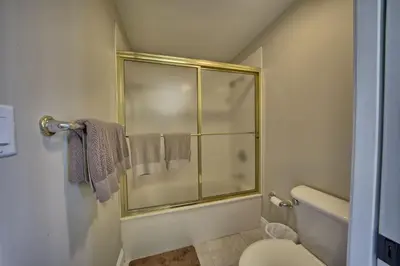 a bathroom with a shower with a toilet and towels at Roomy Oceanfront Condo with Breathtaking View and Beachside Pool - Unit 1906 in Panama City Beach