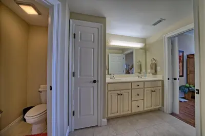 a bathroom with a sink and a toilet and a mirror at Roomy Oceanfront Condo with Breathtaking View and Beachside Pool - Unit 1906 in Panama City Beach