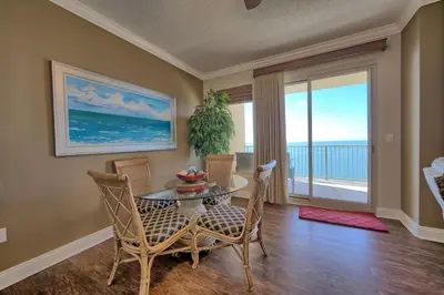 a dining room with a table and chairs and a large window at Roomy Oceanfront Condo with Breathtaking View and Beachside Pool - Unit 1906 in Panama City Beach