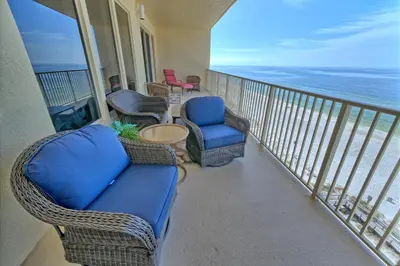 a balcony with a couch and chairs and the ocean at Marvelous Condo with Beachside Pool and Free Poolside WiFi - Unit 0902 in Panama City Beach