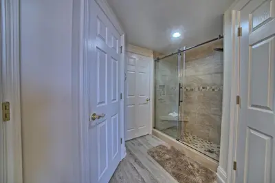 a bathroom with a shower and a white door at Marvelous Condo with Beachside Pool and Free Poolside WiFi - Unit 0902 in Panama City Beach