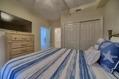 a bedroom with a bed with a tv on the wall at Marvelous Condo with Beachside Pool and Free Poolside WiFi - Unit 0902 in Panama City Beach