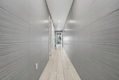a hallway with white walls and a tile floor at The Summit 1217 in Panama City Beach