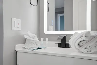a bathroom with a sink with a mirror and towels at The Summit 1217 in Panama City Beach