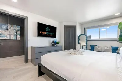 a bedroom with a large bed and a tv on the wall at The Summit 1205 in Panama City Beach