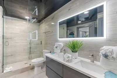 a bathroom with a sink and a toilet and a mirror at The Summit 1205 in Panama City Beach