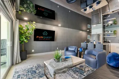 a waiting room with blue chairs and a tv at The Summit 1205 in Panama City Beach