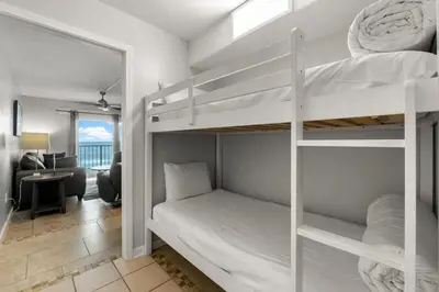 a bedroom with two bunk beds and a desk at The Summit 620 in Panama City Beach