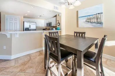 a kitchen and dining room with a wooden table and chairs at Majestic Beach Towers 2-403 in Panama City Beach